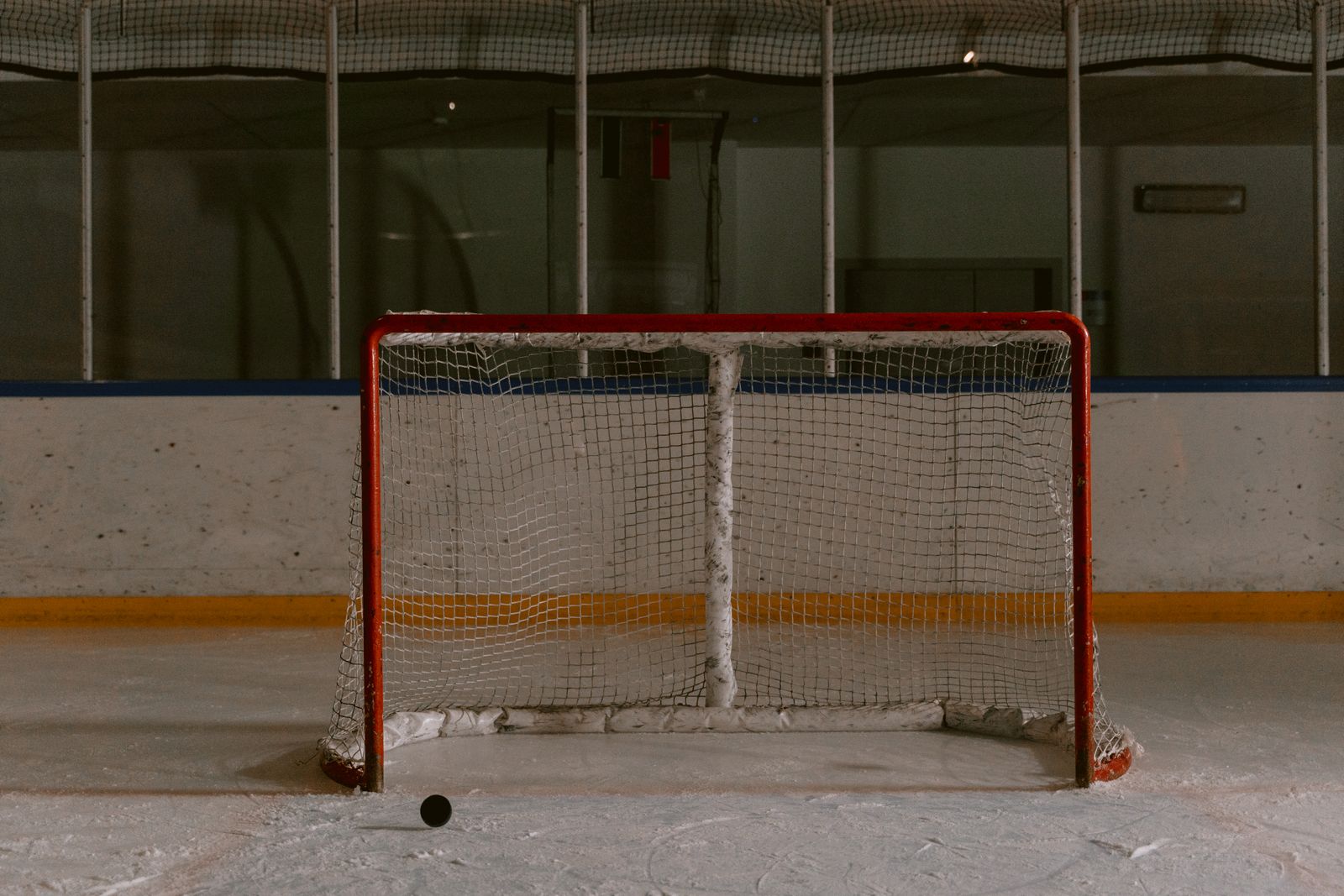 Hockey puck in front of a rink goal